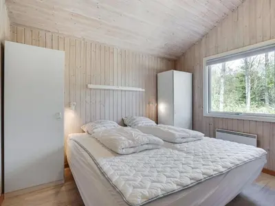 a bedroom with two pillows on a bed with a window at Holiday Home Sonke - 500m from the sea by Interhome in Løkken