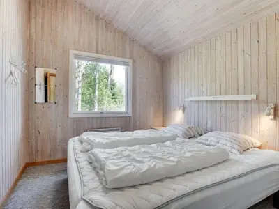 two beds in a room with a window at Holiday Home Sonke - 500m from the sea by Interhome in Løkken