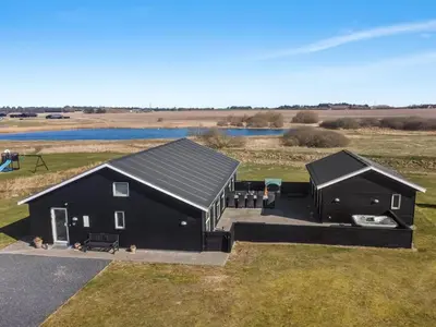 an aerial view of a black house with a pond at Holiday Home Edgar - 1-5km from the sea by Interhome in Løkken