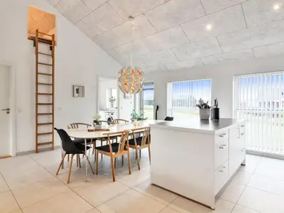 a kitchen and dining room with a table and chairs at Holiday Home Edgar - 1-5km from the sea by Interhome in Løkken