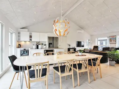 a kitchen and dining room with a table and chairs at Holiday Home Edgar - 1-5km from the sea by Interhome in Løkken