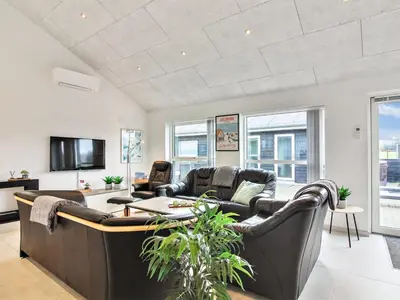 a living room with leather furniture and a tv at Holiday Home Edgar - 1-5km from the sea by Interhome in Løkken