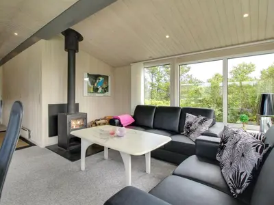 a living room with a couch and a fireplace at Holiday Home Gitten - 600m from the sea by Interhome in Løkken