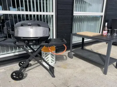 a grill on a picnic table next to a table at Holiday Home Dwerg - 1-5km from the sea by Interhome in Løkken