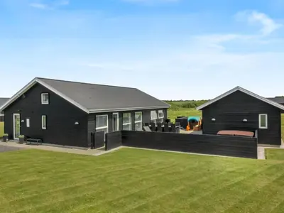 a black house with a large yard at Holiday Home Dwerg - 1-5km from the sea by Interhome in Løkken