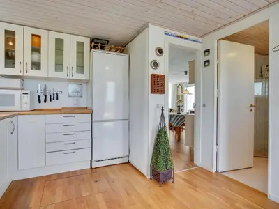 a kitchen with white cabinets and a refrigerator at Holiday Home Ecaterina - 100m from the sea by Interhome in Løkken