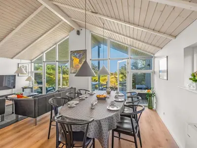 a dining room and kitchen with a table and chairs at Holiday Home Elna - 400m from the sea by Interhome in Løkken
