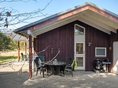 a house with a picnic table outside of it at Holiday Home Herwarth - 3-3km from the sea by Interhome in Blokhus