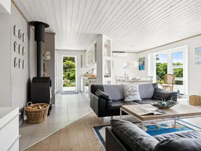 a living room with a couch and a table at Holiday Home Marli - 700m from the sea by Interhome in Blokhus