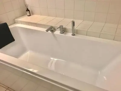 a white bath tub with two faucets in a bathroom at Holiday Home Ønef - 1km from the sea by Interhome in Blokhus
