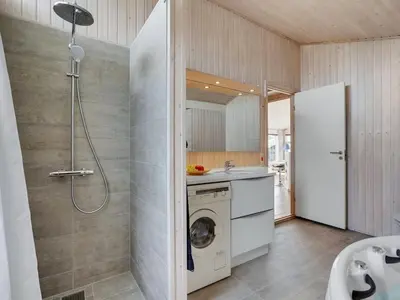 a bathroom with a washing machine and a washer at Holiday Home Nedelko - 250m from the sea by Interhome in Blokhus
