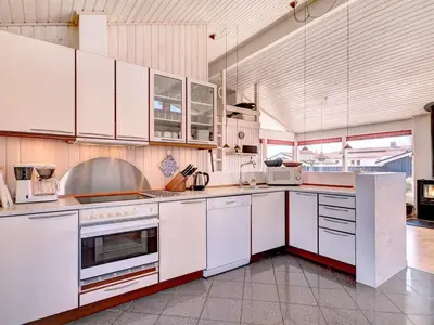 a large kitchen with white cabinets and appliances at Holiday Home Nedelko - 250m from the sea by Interhome in Blokhus