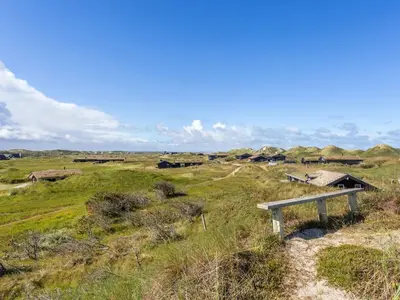 a grassy field with buildings in the distance at Holiday Home Kalervo - 100m from the sea by Interhome in Pandrup