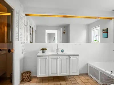 a white bathroom with a sink and a tub at Holiday Home Ingmarie - 1km from the sea by Interhome in Blokhus