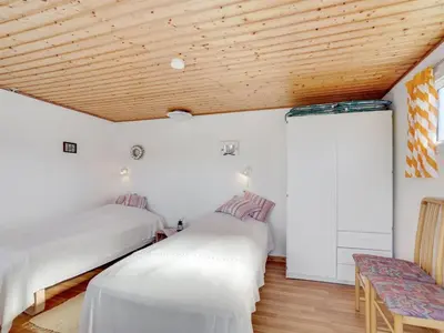 two beds in a room with a wooden ceiling at Holiday Home Ingebritt - 1-5km from the sea by Interhome in Blokhus