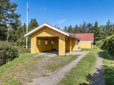 a yellow building with a flag on top at Holiday Home Vetle - 2-8km from the sea by Interhome in Blokhus