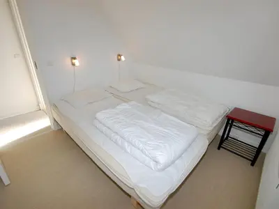 a white bed in a room with two pillows at Holiday Home Stine - 1km from the sea by Interhome in Blokhus