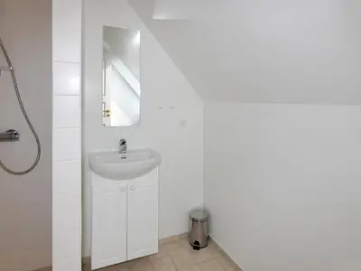 a white bathroom with a sink and a mirror at Holiday Home Stine - 1km from the sea by Interhome in Blokhus