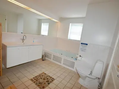 a bathroom with a toilet and a sink and a tub at Holiday Home Stine - 1km from the sea by Interhome in Blokhus
