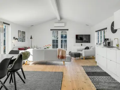 a white living room with a couch and chairs at Holiday Home Wiebke - 200m from the sea by Interhome in Blokhus