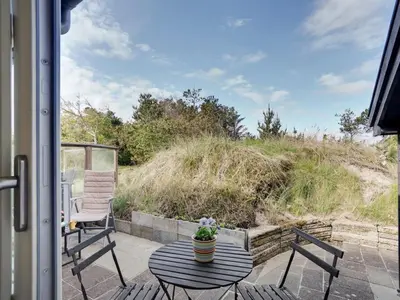 a patio with two chairs and a table on a porch at Holiday Home Ninna - 1km from the sea by Interhome in Blokhus