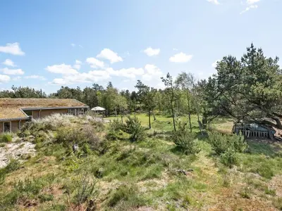 an open field with a house and trees at Holiday Home Ninna - 1km from the sea by Interhome in Blokhus