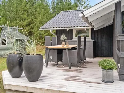 a wooden deck with a table and chairs on it at Holiday Home Elayne - 3km from the sea by Interhome in Blokhus