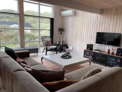 a living room with a couch and a table at Holiday Home Maren - 150m from the sea by Interhome in Blokhus