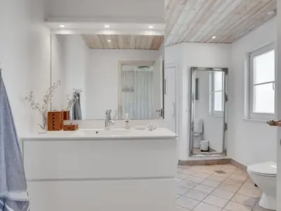a white bathroom with a sink and a toilet at Holiday Home Maren - 150m from the sea by Interhome in Blokhus