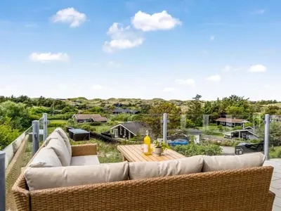a living room with a couch and a table at Holiday Home Skamhals - 700m from the sea by Interhome in Blokhus