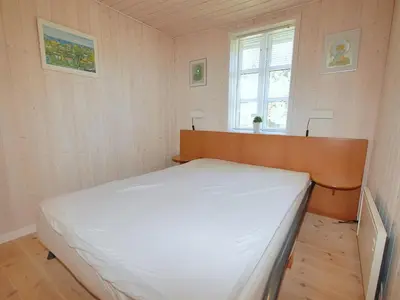 a small bedroom with a white bed in it at Holiday Home Tomke - 1-7km from the sea by Interhome in Blokhus