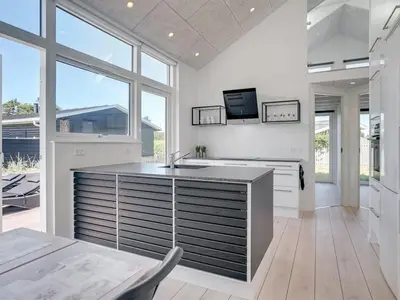 a kitchen with white walls and a large window at Holiday Home Erk - 700m from the sea by Interhome in Blokhus