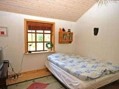 a bedroom with a bed in a room with a window at Holiday Home Tajo - 1km from the sea by Interhome in Blokhus
