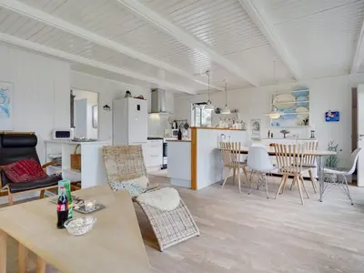 a living room and kitchen with a table and chairs at Holiday Home Bernadeta - 1-2km from the sea by Interhome in Blokhus