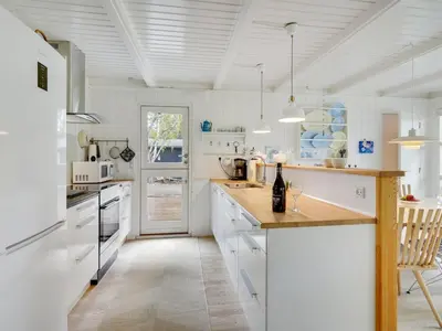 a kitchen with white cabinets and a counter top at Holiday Home Bernadeta - 1-2km from the sea by Interhome in Blokhus