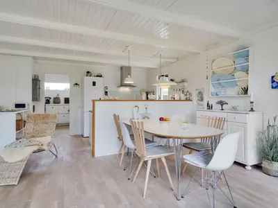 a kitchen and dining room with a table and chairs at Holiday Home Bernadeta - 1-2km from the sea by Interhome in Blokhus