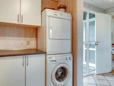 a kitchen with a washer and dryer in it at Holiday Home Alrune - 800m from the sea by Interhome in Blokhus