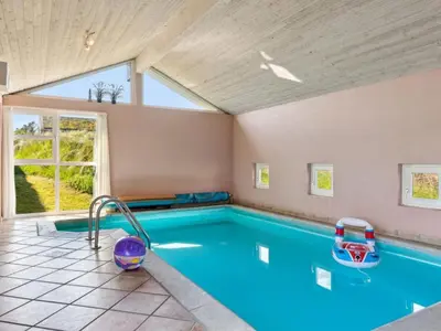 a swimming pool in a house with a window at Holiday Home Alrune - 800m from the sea by Interhome in Blokhus