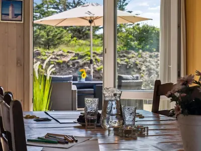 a table with a glass vase on top of it at Holiday Home Alrune - 800m from the sea by Interhome in Blokhus