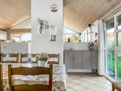 a dining room with a table and chairs at Holiday Home Alrune - 800m from the sea by Interhome in Blokhus
