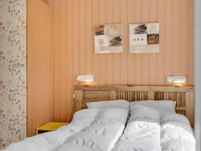 a bed in a bedroom with two lamps on the wall at Holiday Home Noralee - 3-5km from the sea by Interhome in Blokhus