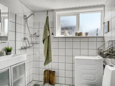 a white bathroom with a shower and a sink at Holiday Home Ozan - 400m from the sea by Interhome in Blokhus