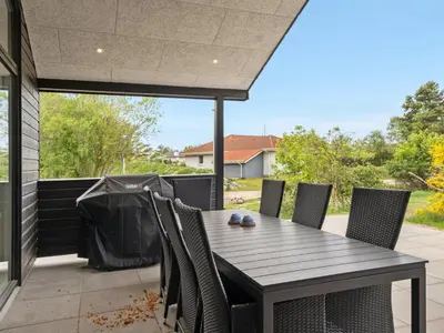 a wooden table and chairs on a patio at Holiday Home Antonina - 800m from the sea by Interhome in Blokhus