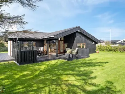 a black house with a large yard at Holiday Home Friderike - 200m from the sea by Interhome in Blokhus