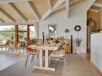 a dining room and living room with a table and chairs at Holiday Home Friderike - 200m from the sea by Interhome in Blokhus