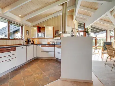 a large kitchen with white cabinets and a table at Holiday Home Friderike - 200m from the sea by Interhome in Blokhus