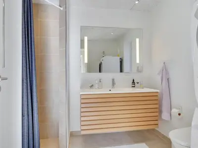 a bathroom with a sink and a mirror at Holiday Home Shiva - 300m from the sea by Interhome in Blokhus
