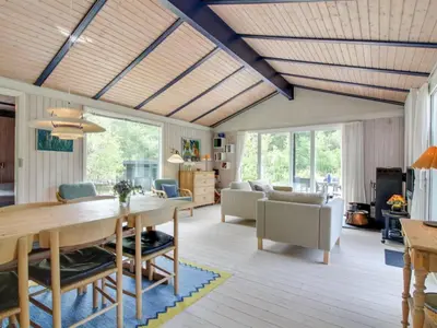 a living room with a dining room table and chairs at Holiday Home Heike - 1-3km from the sea by Interhome in Blokhus