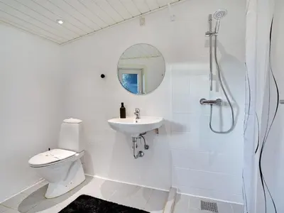 a bathroom with a toilet and a sink and a shower at Holiday Home Pelle - 800m from the sea by Interhome in Blokhus