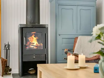 a living room with a fireplace with two lit candles at Holiday Home Eimi - 1-5km from the sea by Interhome in Blokhus